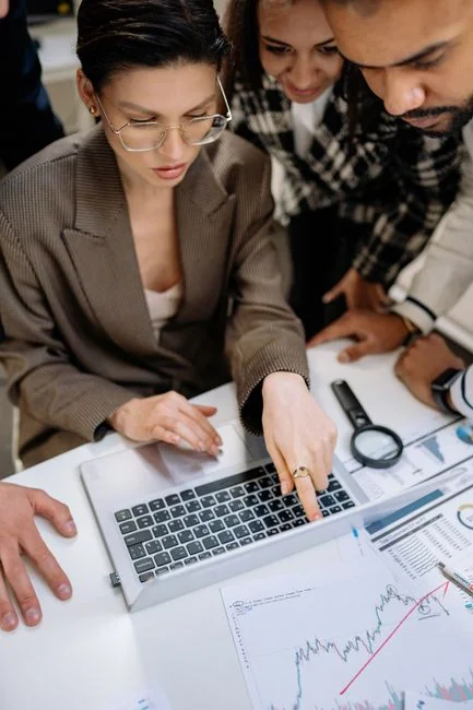 Une équipe variée travaillant ensemble sur des stratégies de marketing digital autour d’un bureau, avec des ordinateurs portables et des tablettes.